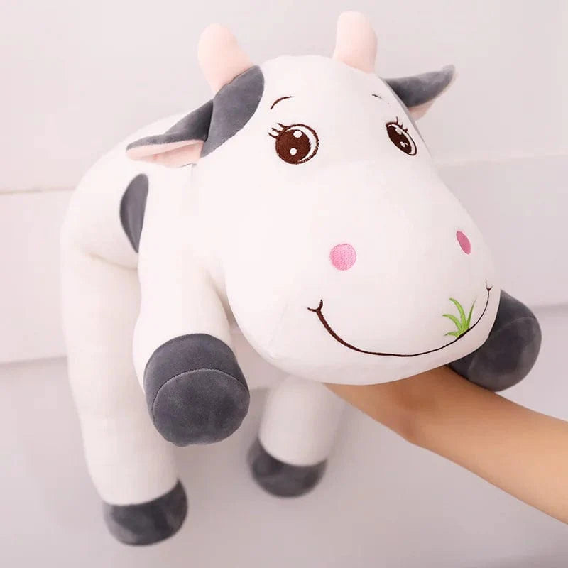 Peluche vache colorée en train de brouter de l'herbe