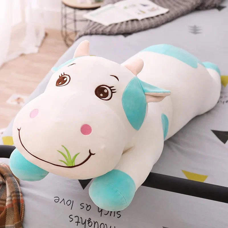 Peluche vache colorée en train de brouter de l'herbe