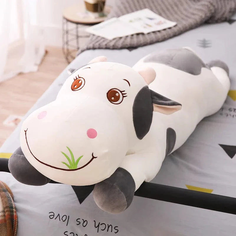 Peluche vache colorée en train de brouter de l'herbe