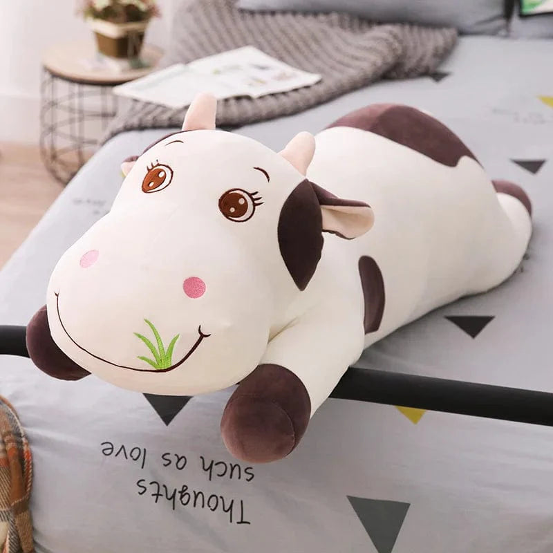 Peluche vache colorée en train de brouter de l'herbe