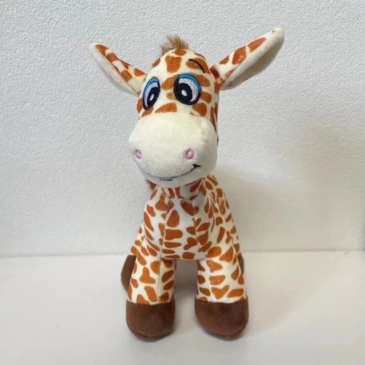 Peluche girafe aux yeux grandioses