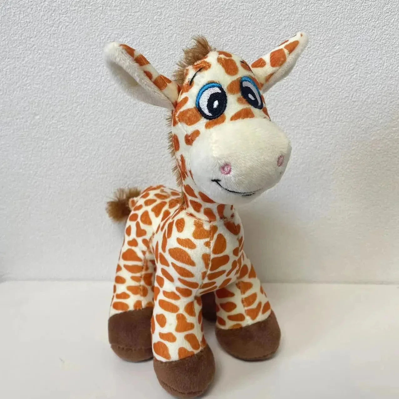 Peluche girafe aux yeux grandioses