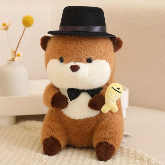 Peluche Loutre avec Chapeau Tenant un Poisson Coloré.