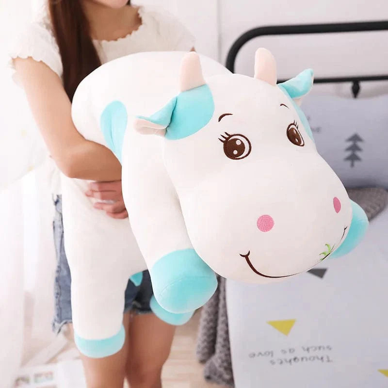 Peluche vache colorée en train de brouter de l'herbe
