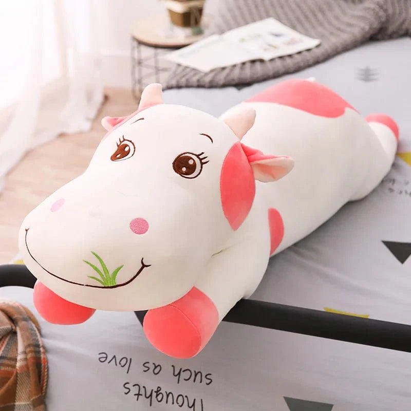 Peluche vache colorée en train de brouter de l'herbe